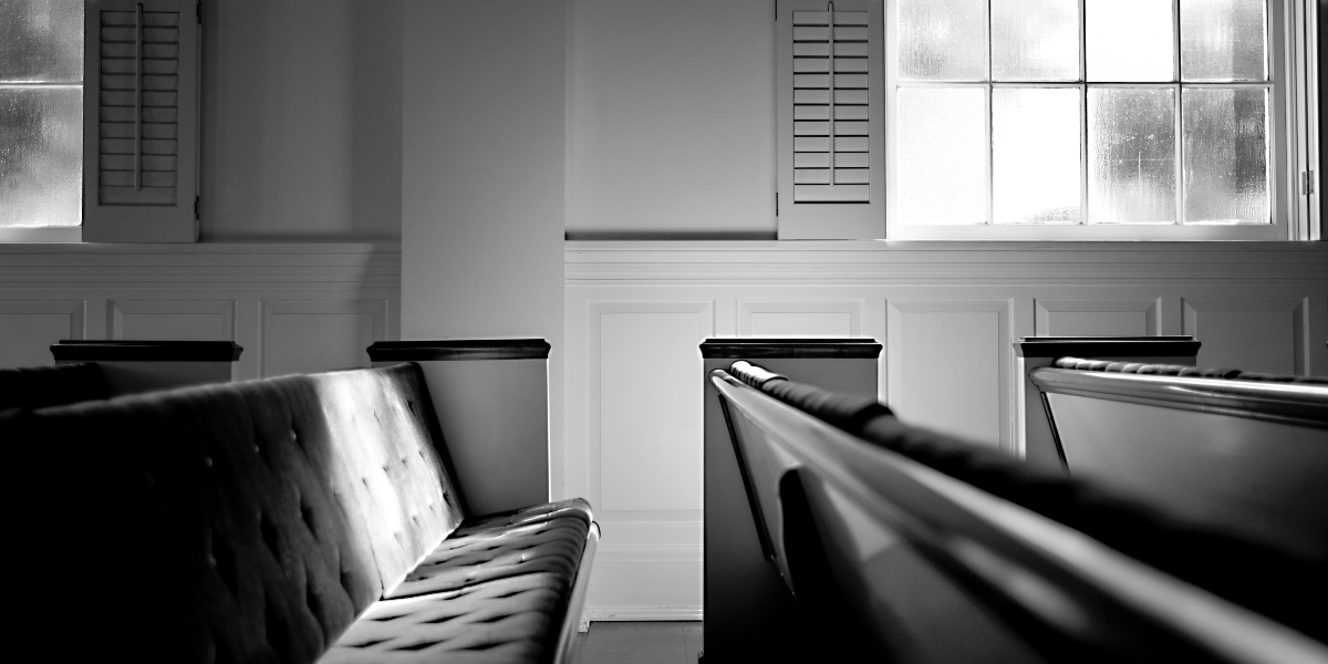 Empty church pews and sanctuary windows in black and white, evoking the enduring call to faithful Word-centered ministry explored in Harold Senkbeil's The Culture of God's Word