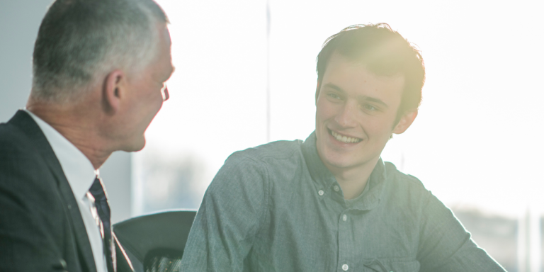 An older pastor mentoring a younger man, reflecting the call to identify and develop spiritually mature future ministers