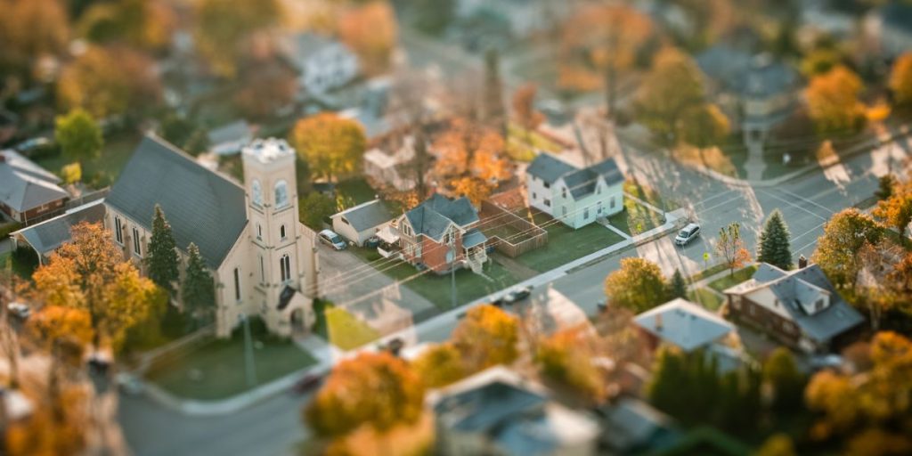 Charles Cotherman's Strip Mine Jesus explores loving a place that suffers through ministry in small towns and overlooked places, pictured as an aerial autumn view of a church rooted in its rural community.
